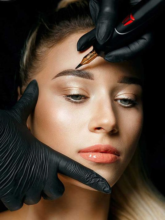 Kosmetikerin in Handschuhen macht Permanent Make-up