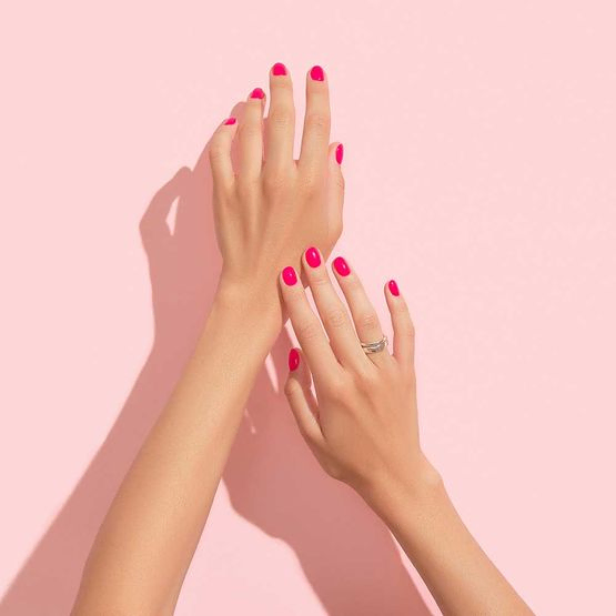 Frauenhände mit rosa Nageldesign. Maniküre, Pediküre-Schönheitssalon-Konzept